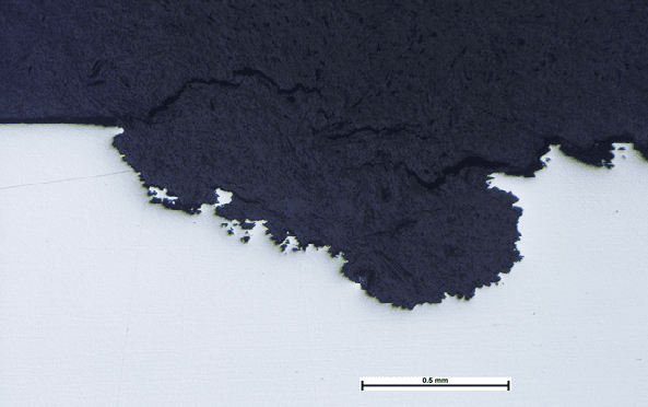 Photomicrograph of a section through a shallow pit in an austenitic stainless steel | Pitting Corrosion