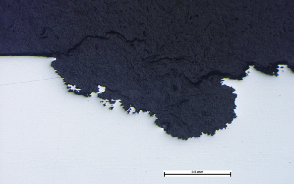 Photomicrograph of a section through a shallow pit in an austenitic stainless steel | Pitting Corrosion