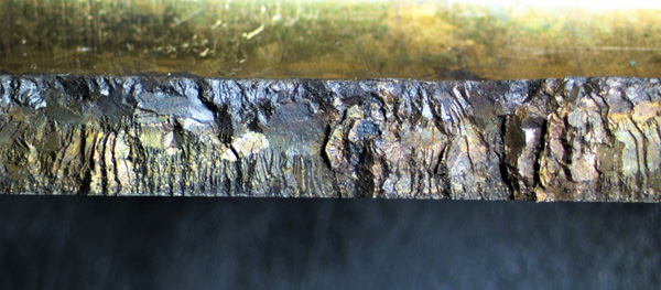 Exposed fracture face of SCC in a brass component showing a highly brittle surface with corrosion staining