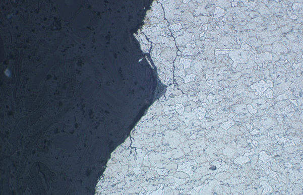 Section through the fracture face of a low carbon steel showing branched stress corrosion cracking extending into the metal x200 Mag